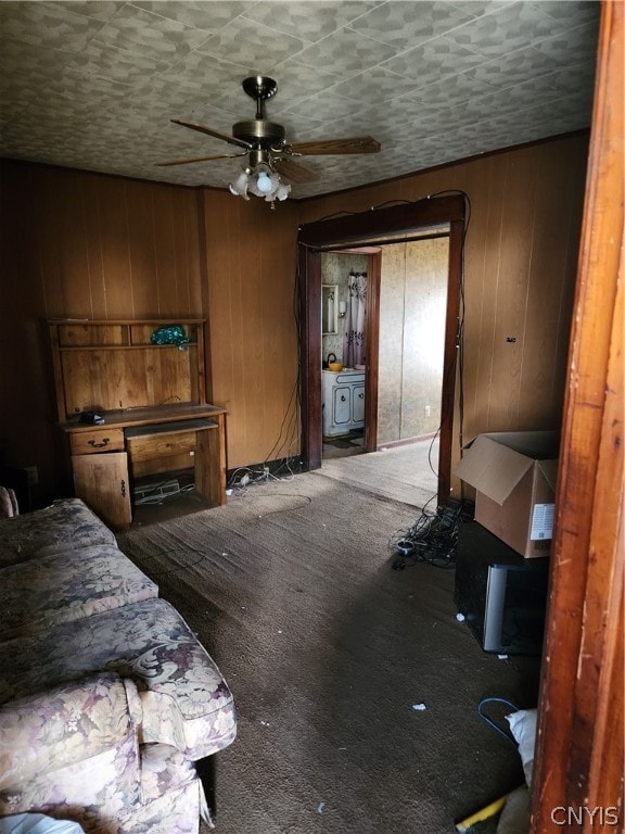 carpeted bedroom featuring ceiling fan and wooden walls