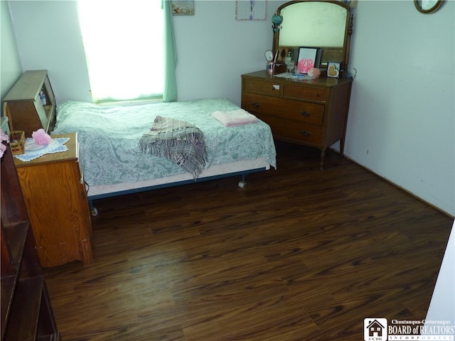 bedroom with dark hardwood / wood-style flooring