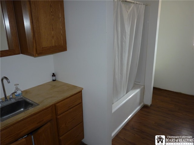 bathroom featuring vanity, hardwood / wood-style floors, and shower / tub combo with curtain