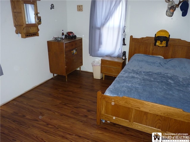 bedroom with dark hardwood / wood-style flooring