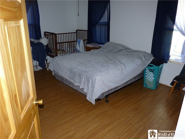 bedroom with dark hardwood / wood-style flooring