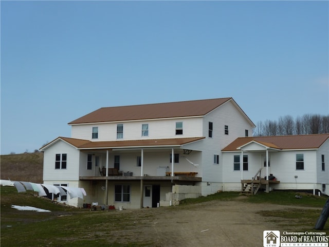 rear view of property featuring covered porch