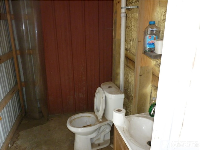 bathroom with wooden walls and toilet