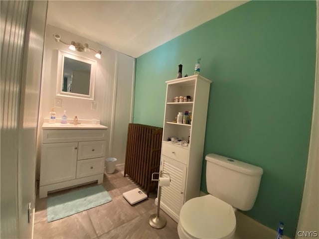 bathroom with toilet, vanity, and tile flooring