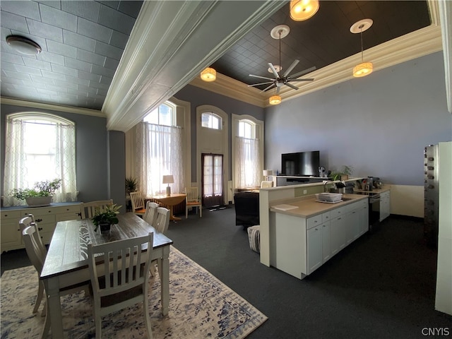 kitchen with dark colored carpet, ceiling fan, white cabinetry, and a wealth of natural light