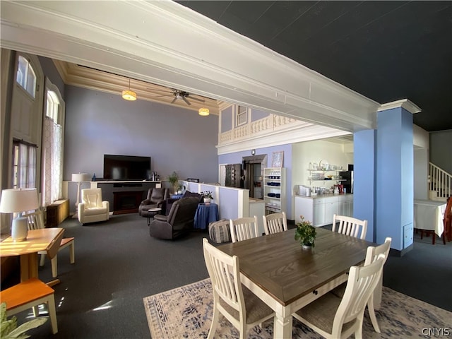 carpeted dining space featuring ceiling fan and ornamental molding