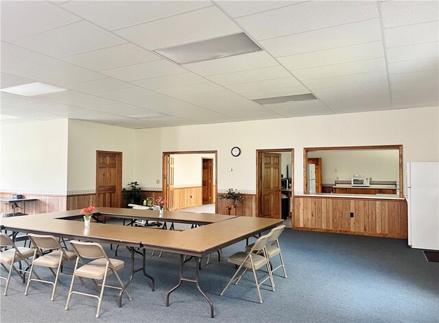 carpeted dining room with a drop ceiling