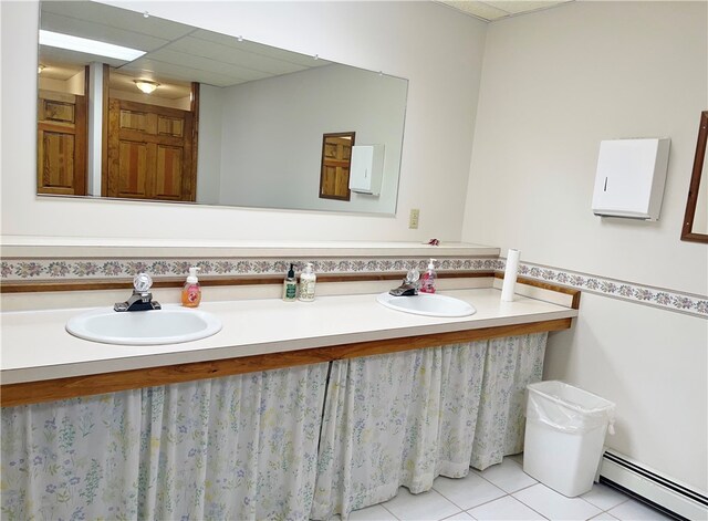 bathroom with double vanity, a baseboard radiator, and tile flooring