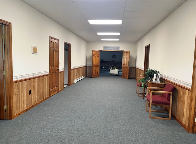 interior space featuring a baseboard heating unit and dark carpet