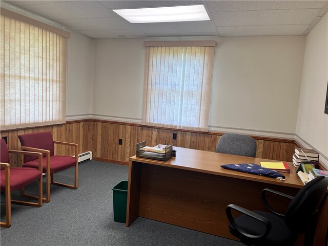 carpeted office featuring a baseboard heating unit and a paneled ceiling