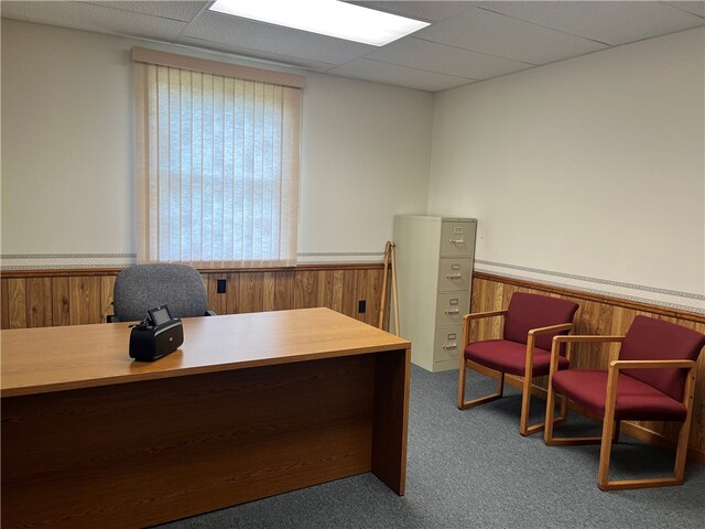 carpeted home office with a paneled ceiling