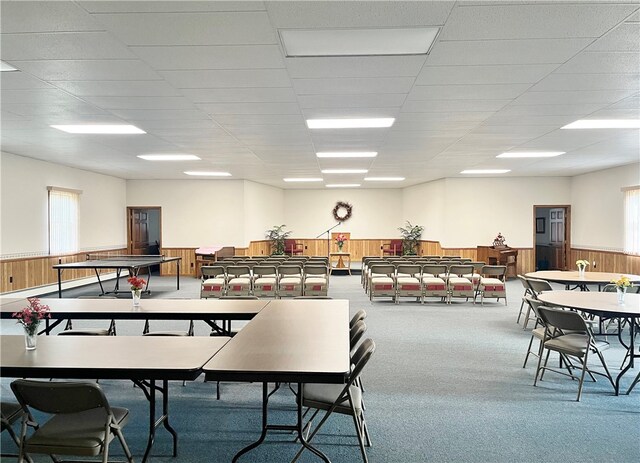 carpeted dining space featuring a paneled ceiling