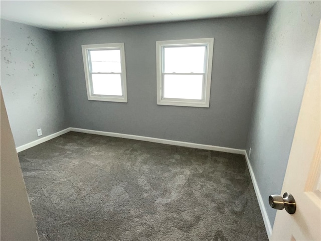 unfurnished room featuring dark carpet