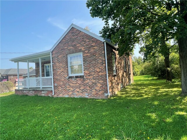 view of property exterior featuring a lawn and covered porch