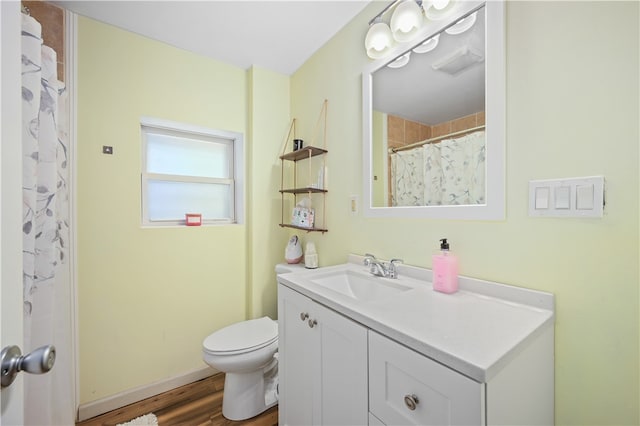 bathroom with toilet, vanity, and wood-type flooring