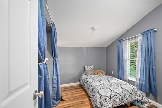 bedroom with hardwood / wood-style floors and vaulted ceiling