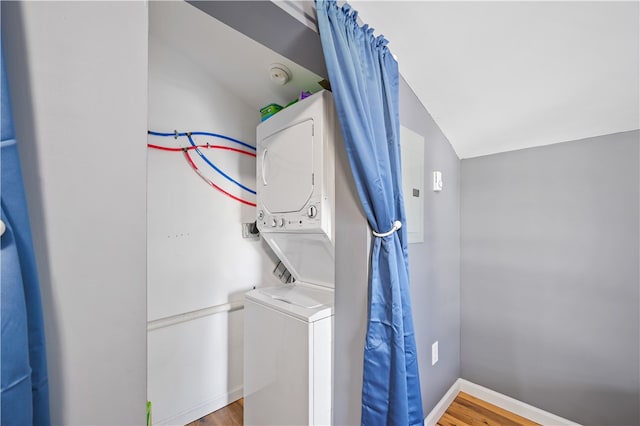 washroom with stacked washer / drying machine, washer hookup, and hardwood / wood-style flooring