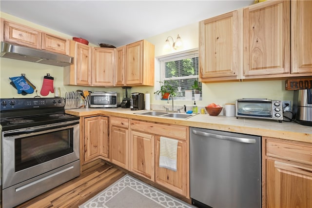 kitchen featuring light brown cabinetry, light hardwood / wood-style flooring, appliances with stainless steel finishes, and sink