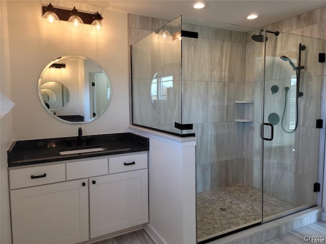 bathroom with vanity and a shower with shower door