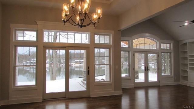 doorway to outside with ceiling fan with notable chandelier, french doors, dark hardwood / wood-style flooring, and built in features