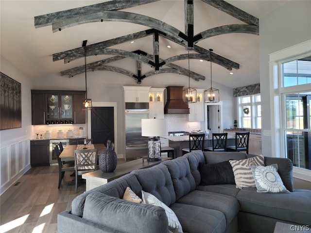 living room with high vaulted ceiling, light hardwood / wood-style floors, and wine cooler