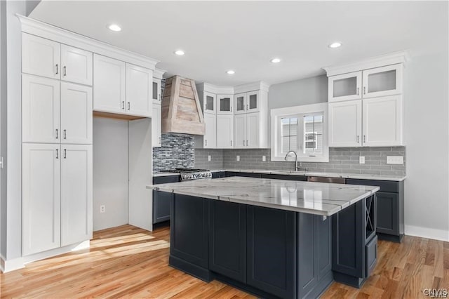 kitchen featuring premium range hood, white cabinetry, and a center island