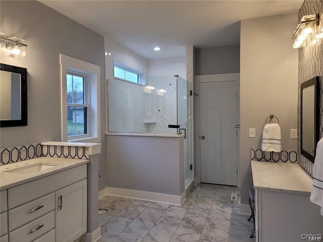 bathroom featuring a shower with door and vanity