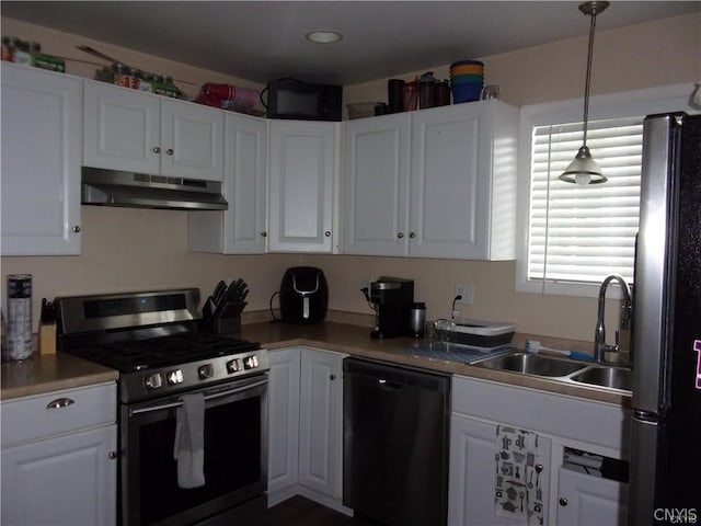 kitchen featuring white cabinets, stainless steel appliances, decorative light fixtures, and sink