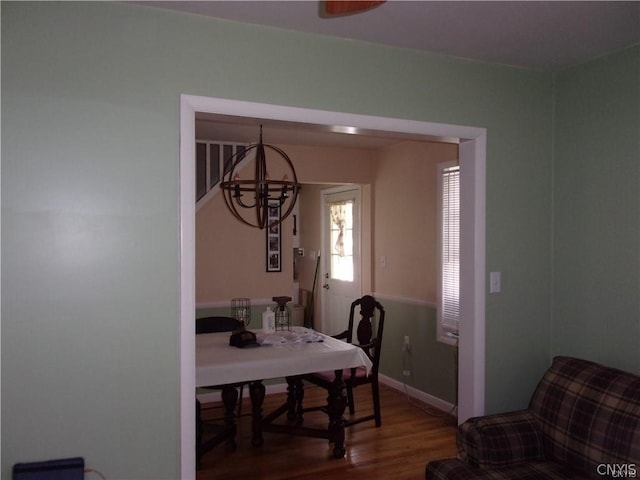 dining area with dark wood-type flooring and a chandelier