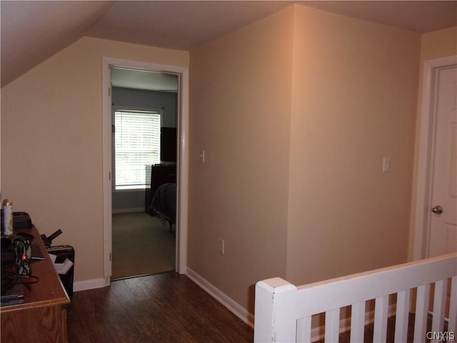 hall with vaulted ceiling and dark hardwood / wood-style flooring