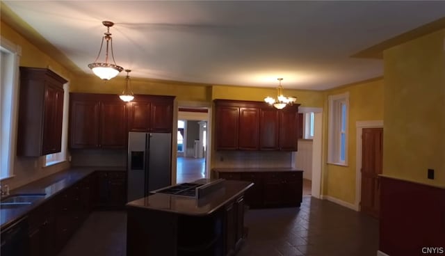 kitchen with a kitchen island, a notable chandelier, backsplash, sink, and fridge with ice dispenser