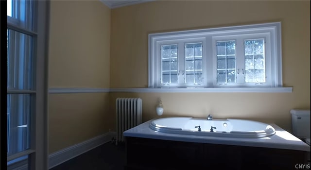 bathroom featuring radiator heating unit, toilet, and a washtub