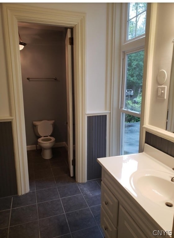 bathroom with tile floors, toilet, and vanity