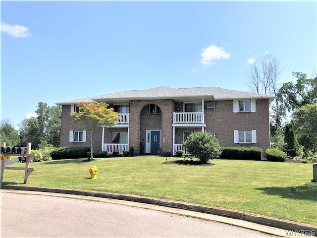 view of front facade with a front lawn and a balcony