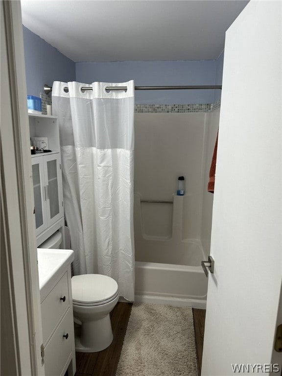 full bathroom with shower / bathtub combination with curtain, toilet, hardwood / wood-style flooring, and vanity