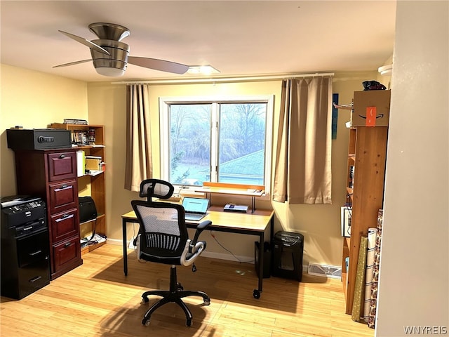 home office with light hardwood / wood-style floors and ceiling fan