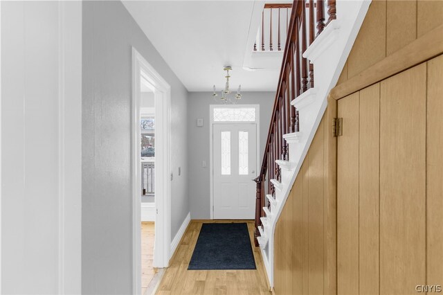 entryway with light hardwood / wood-style flooring and a chandelier