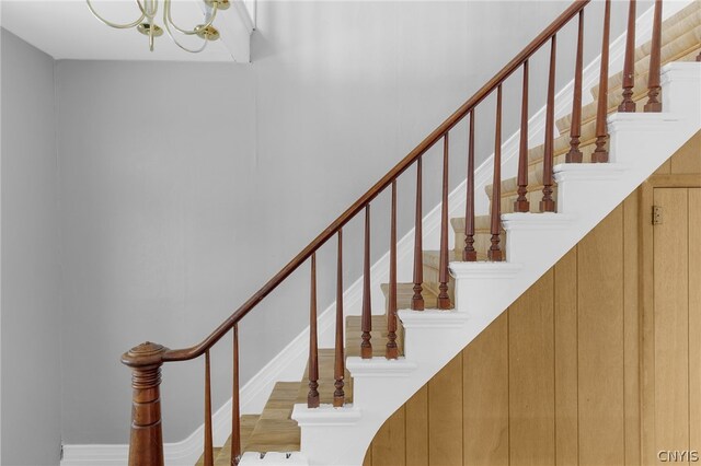 stairs with a notable chandelier and light hardwood / wood-style flooring