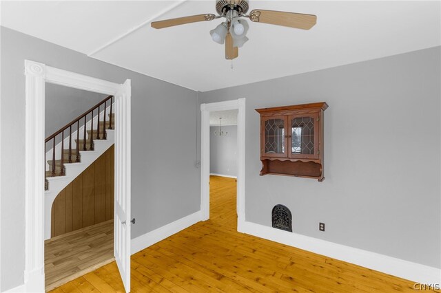 empty room with ceiling fan and light hardwood / wood-style flooring