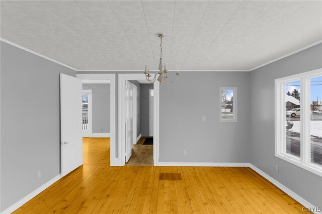 unfurnished dining area with light hardwood / wood-style flooring, crown molding, and a chandelier