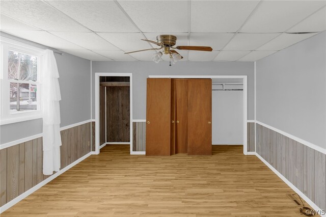 unfurnished bedroom with ceiling fan, a paneled ceiling, and light hardwood / wood-style flooring