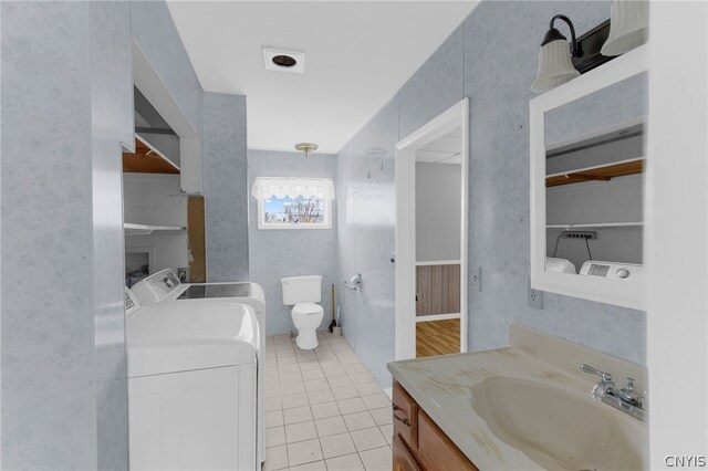 bathroom with hardwood / wood-style floors, vanity, washer and dryer, and toilet