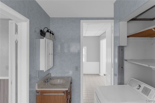 bathroom featuring vanity, tile patterned floors, and washer / dryer