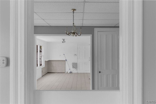 room details with a paneled ceiling, tile patterned flooring, and a chandelier