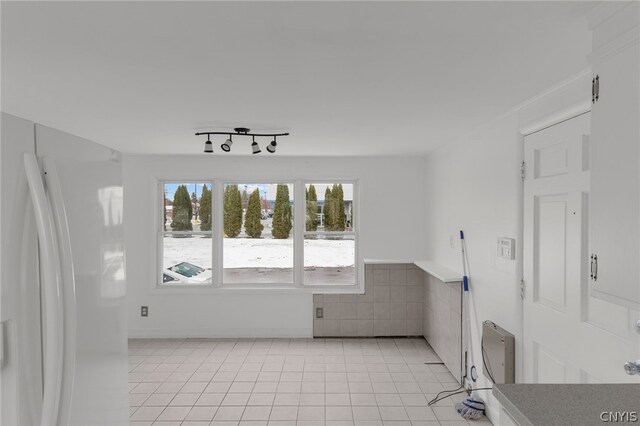 spare room with rail lighting and light tile patterned floors