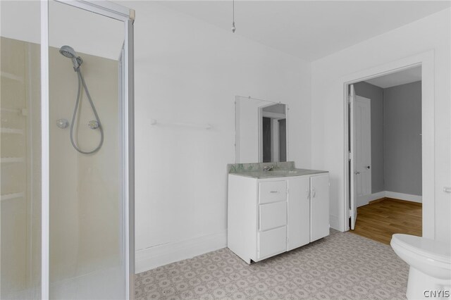 bathroom with vanity, tile patterned flooring, toilet, and a shower