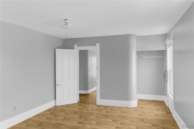 unfurnished bedroom featuring light hardwood / wood-style flooring and a closet