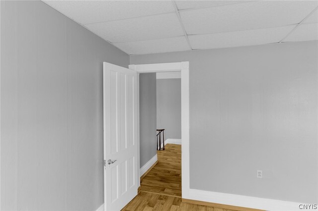 empty room featuring wood-type flooring and a paneled ceiling