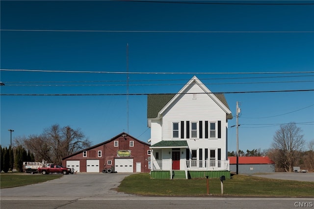 view of front facade featuring a garage, a porch, and a front lawn