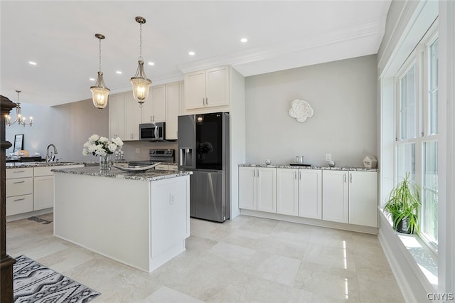 kitchen featuring an inviting chandelier, pendant lighting, stainless steel appliances, stone countertops, and white cabinets